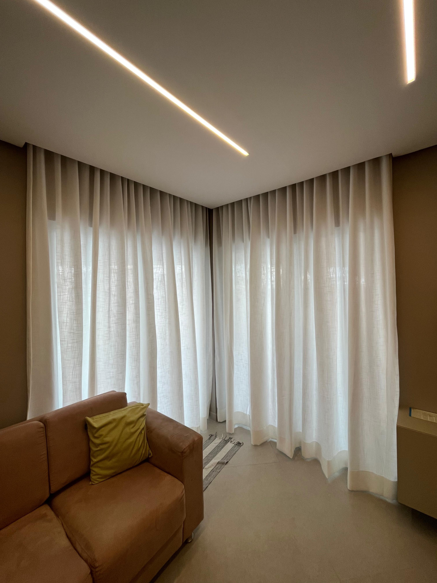 Sala com cortinas de tecido sob medida em trilho, do teto ao chão